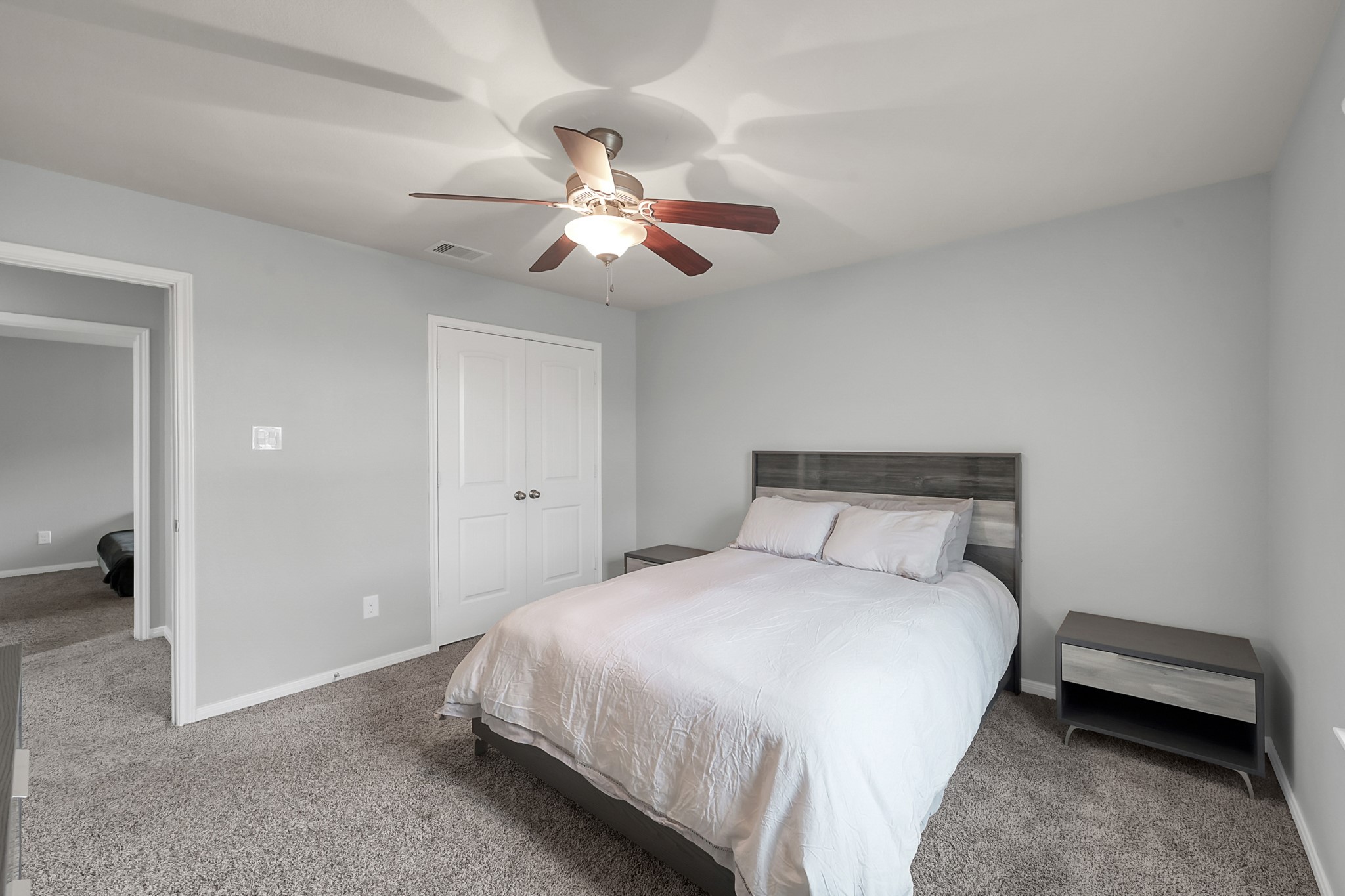 24542 Grayson Falls Lane Spring, TX 77389 - Photo 35 of 48 This 5th bedroom features soft gray walls and plush carpeting, creating a cozy atmosphere. It includes a ceiling fan, a double-door closet, and ample natural light.