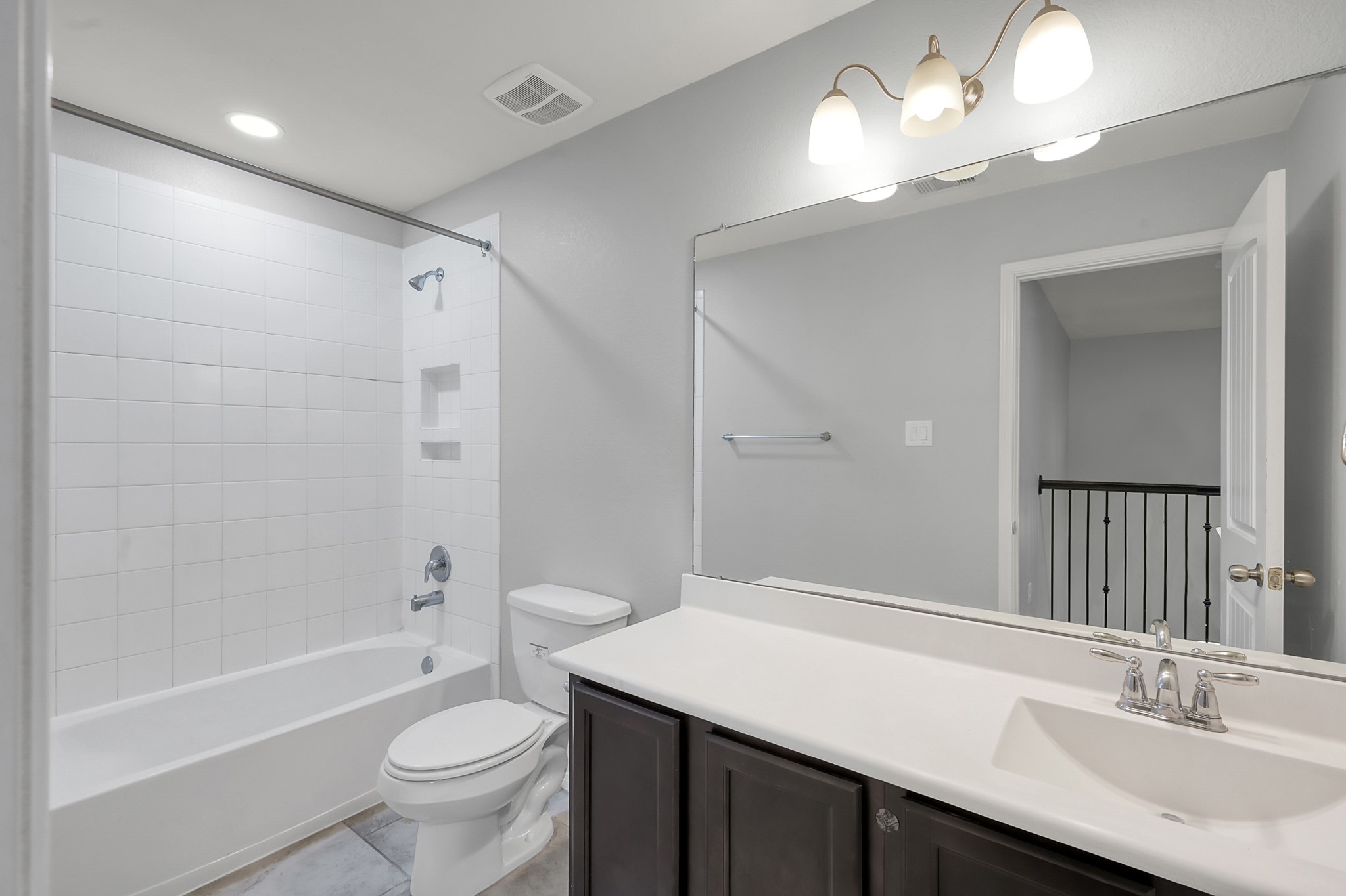 24542 Grayson Falls Lane Spring, TX 77389 - Photo 36 of 48 This 4th bathroom features a modern design with a white tiled shower-bathtub combo, large mirror, sleek vanity with ample counter space, and elegant lighting fixtures, creating a bright and clean atmosphere.