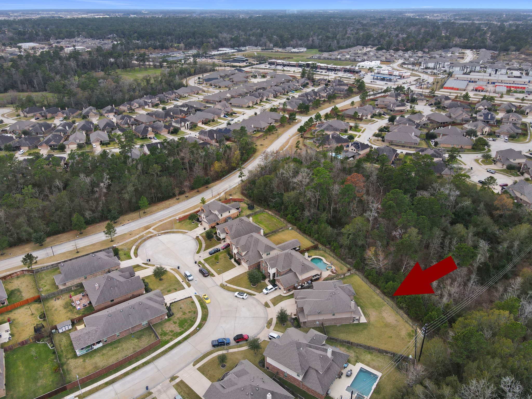 24542 Grayson Falls Lane Spring, TX 77389 - Photo 40 of 48 This aerial photo showcases the suburban neighborhood with spacious homes, many featuring pools. The area is surrounded by lush greenery, providing a sense of privacy and tranquility. Nearby, there are essential amenities and shopping centers, adding convenience to the peaceful setting.
