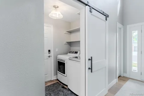 a view of washer and dryer with bathroom in the background