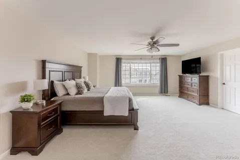 a spacious bedroom with a bed a dresser and a flat screen tv