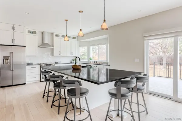 a kitchen with stainless steel appliances kitchen island a table and chairs in it
