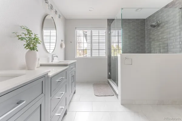 a spacious bathroom with a granite countertop sink a mirror and a shower