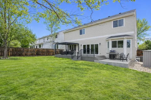 a view of a house with a backyard and a patio