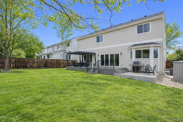 a view of a house with a backyard and a patio