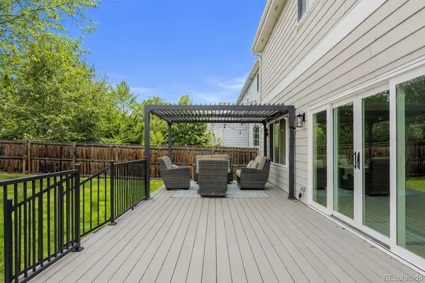 a view of a patio with couches chairs and wooden floor