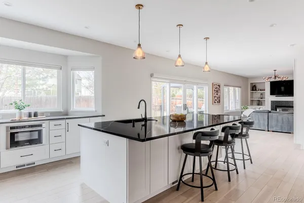 a kitchen with granite countertop a stove a sink a dining table and chairs