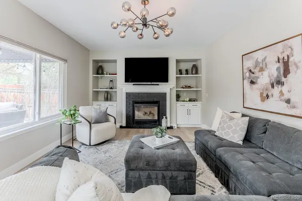 a living room with furniture a flat screen tv and a fireplace