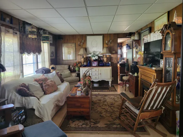 a living room with furniture a flat screen tv and a large window