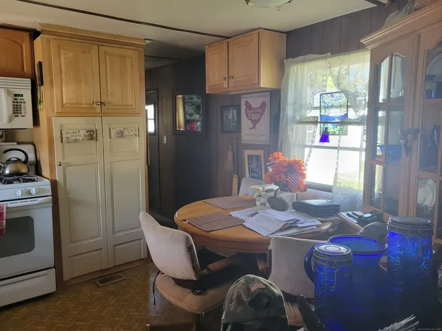 a view of a dining room with furniture a kitchen and chandelier