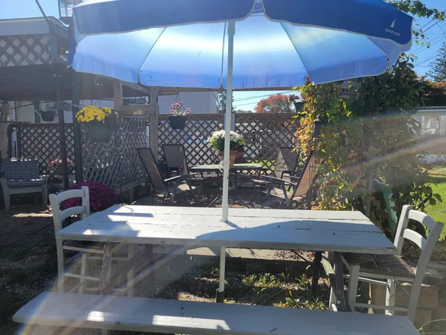a view of a patio with table and chairs under an umbrella