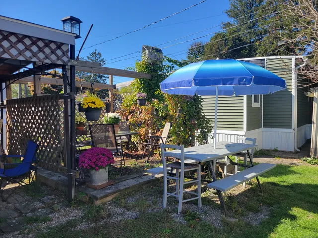 a view of a patio with table and chairs under an umbrella