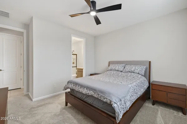 a large bed sitting in a bedroom next to a window and a chandelier