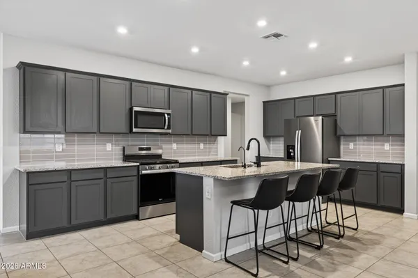 a kitchen with stainless steel appliances granite countertop a stove top oven a refrigerator a sink and dishwasher