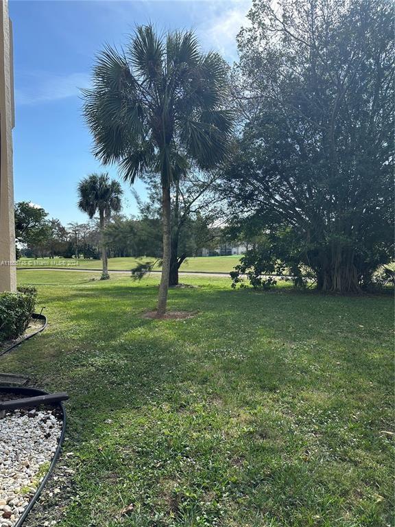7950 West McNab Road, Unit 106 Tamarac, FL 33321 - Photo 30 of 33 a view of outdoor space with deck and trees
