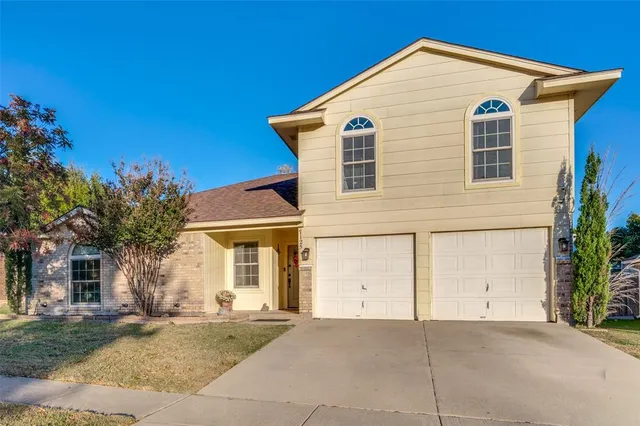 a view of a house with a yard and potted plants