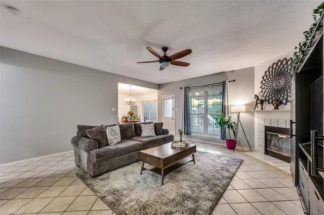 a living room with furniture a fireplace and a chandelier