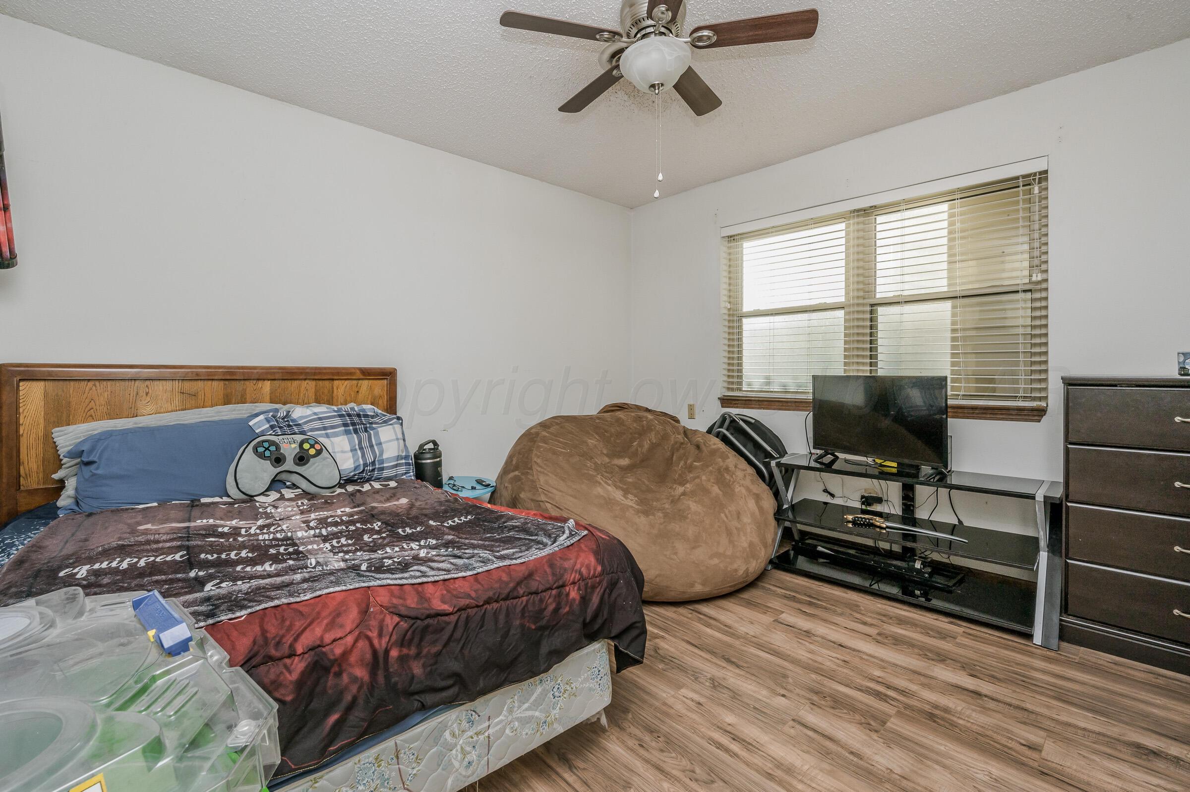 4932 South Georgia Street Amarillo, TX 79110 - Photo 15 of 23 a bedroom with a bed and wooden floor