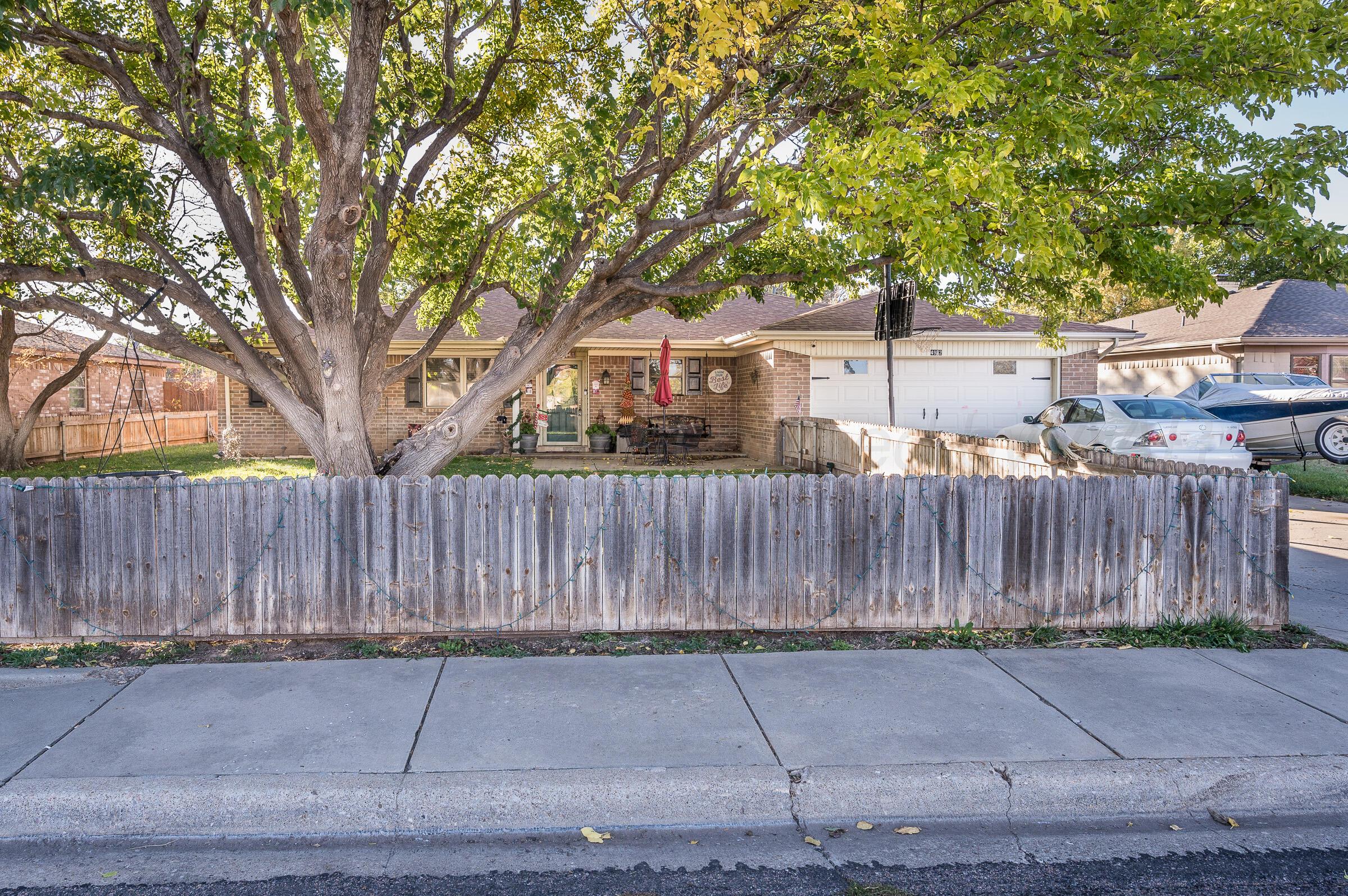 4932 South Georgia Street Amarillo, TX 79110 - Photo 2 of 23 a front view of a house with a garden