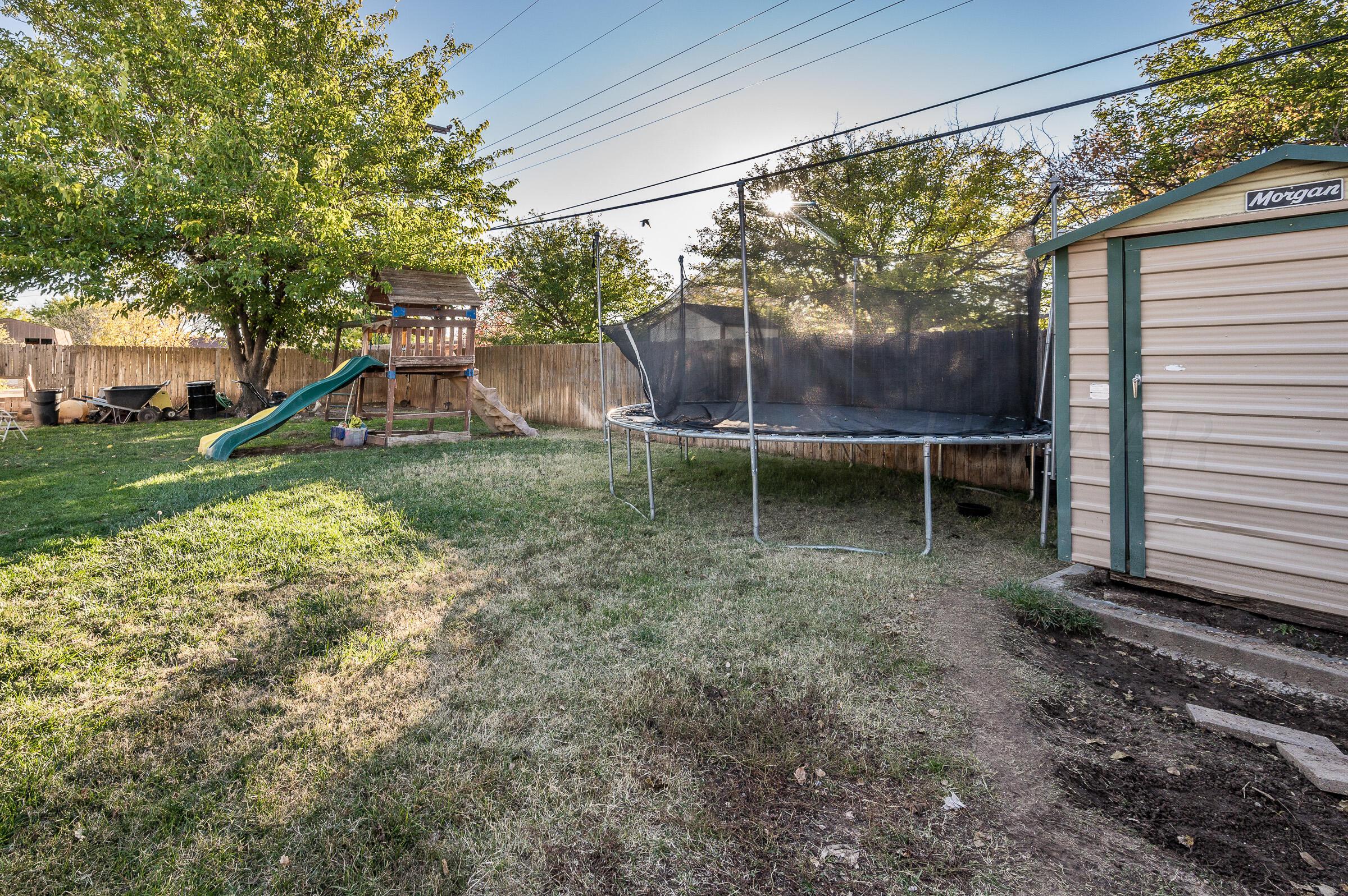 4932 South Georgia Street Amarillo, TX 79110 - Photo 21 of 23 a backyard of a house with wooden fence and large trees