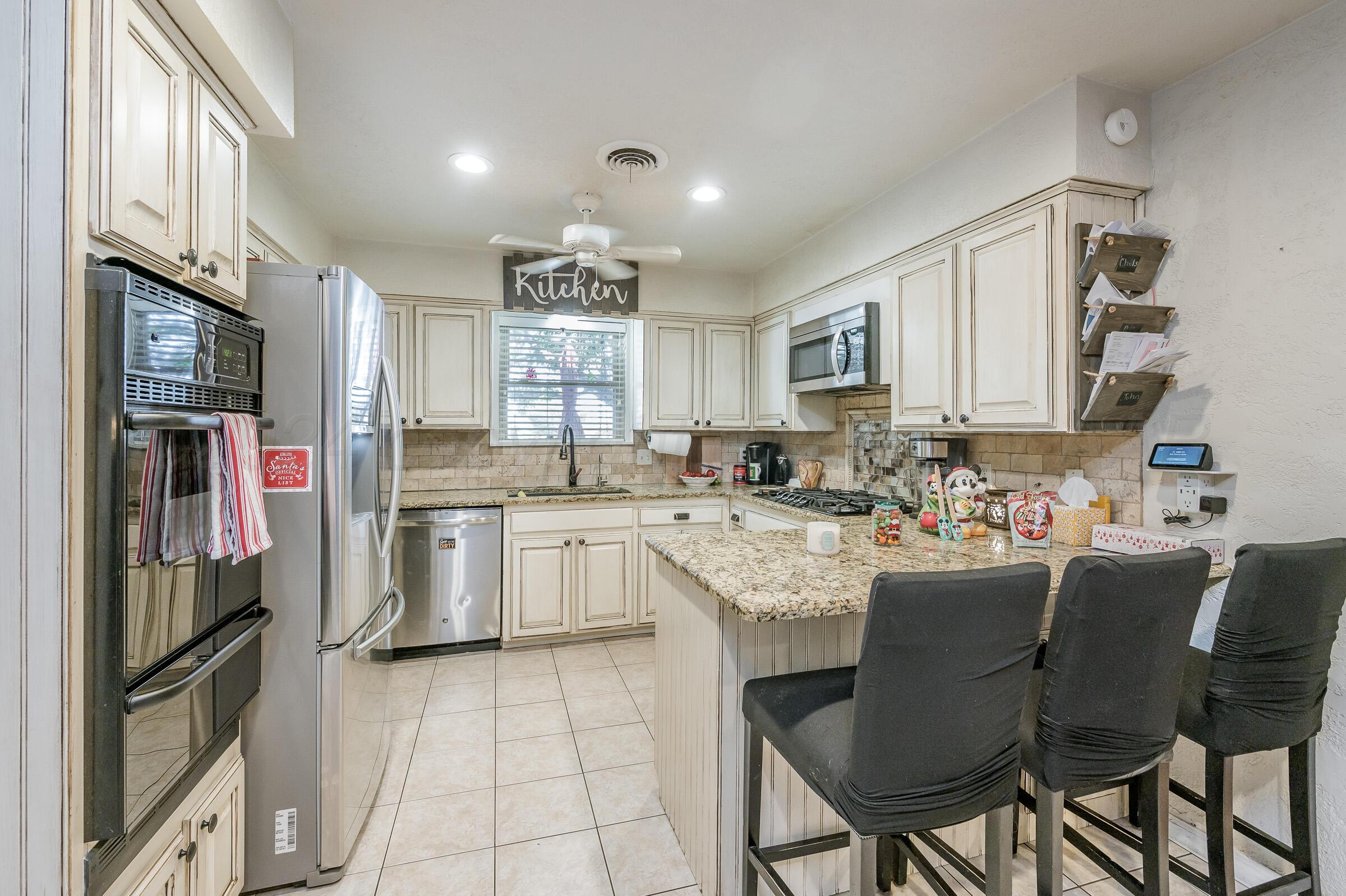 4932 South Georgia Street Amarillo, TX 79110 - Photo 7 of 23 a kitchen with cabinets and chairs
