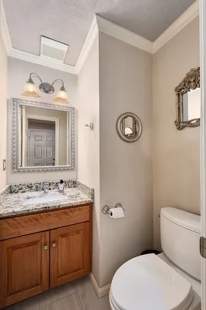 a bathroom with a granite countertop toilet sink and mirror