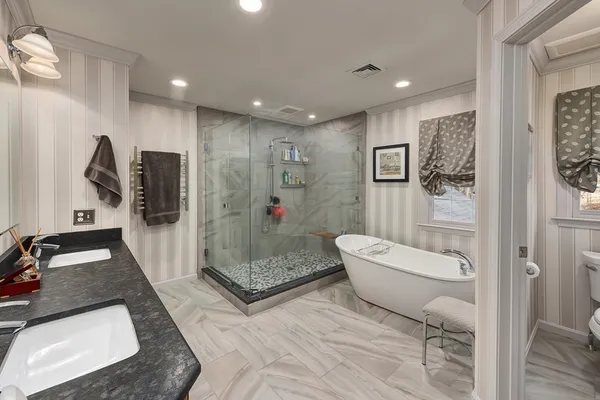 a bathroom with a granite countertop sink a toilet a mirror and shower