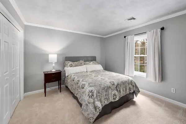 a bedroom with a bed lamp and a window