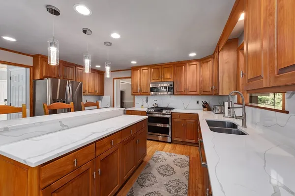 a kitchen with stainless steel appliances granite countertop sink stove top oven and cabinets