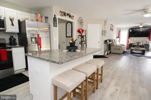 a dining room with furniture a chandelier and wooden floor