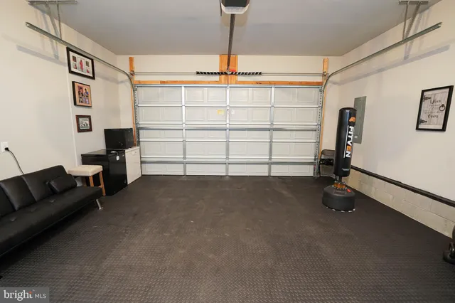 a view of hallway with furniture and a refrigerator