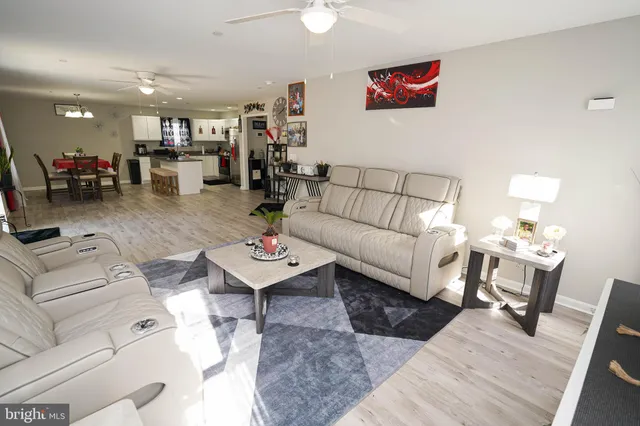 a living room with furniture and a dining table with wooden floor