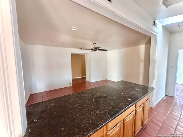 an empty room with windows and ceiling fan
