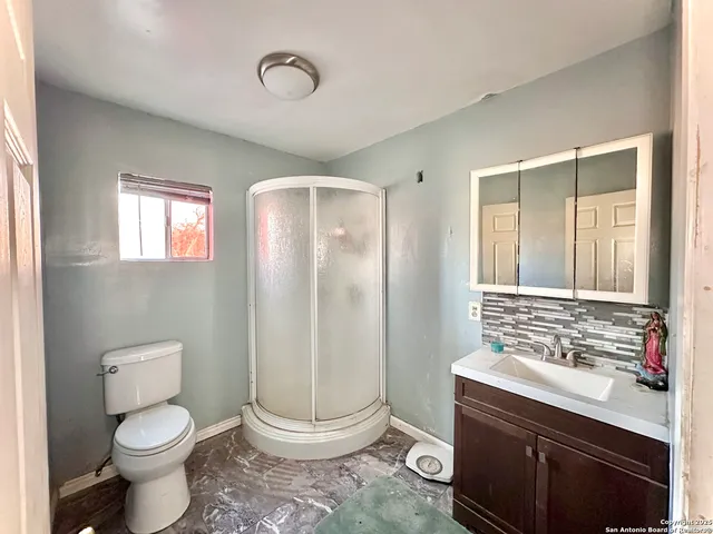 a bathroom with a granite countertop sink toilet and shower