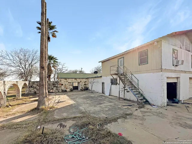 a view of an empty room with wooden floor and windows