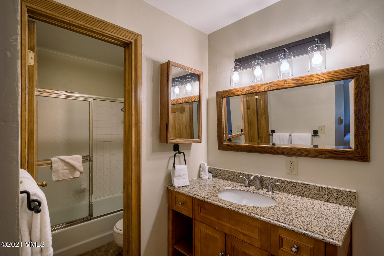 993 Lions Ridge Loop, Unit 331 Vail, CO 81657 - Photo 17 of 20 a bathroom with a granite countertop sink and a mirror