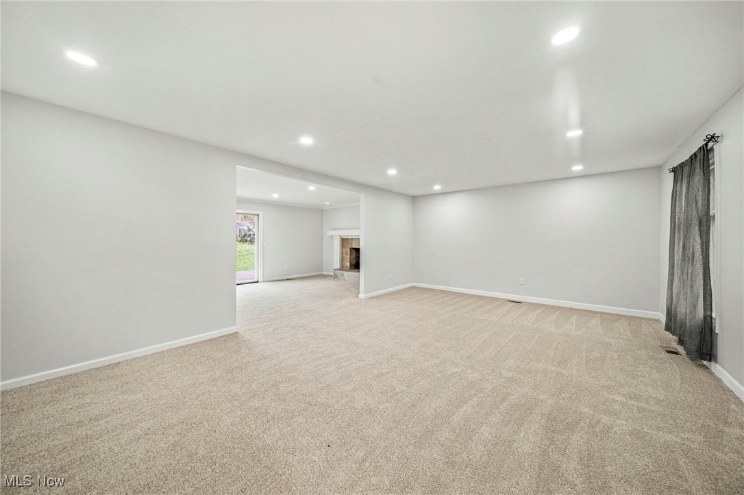 91 Paradise Road Painesville, OH 44077 - Photo 7 of 39 Below grade area with light carpet, recessed lighting, and a fireplace with raised hearth