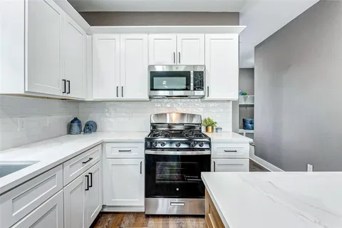 a kitchen with cabinets appliances and a sink
