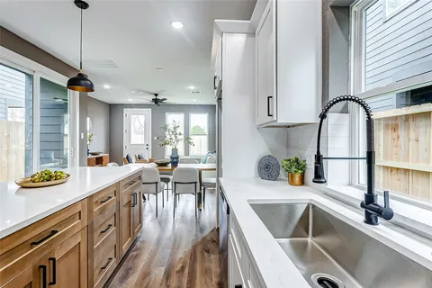 a kitchen with a sink a counter top space a large window and stainless steel appliances
