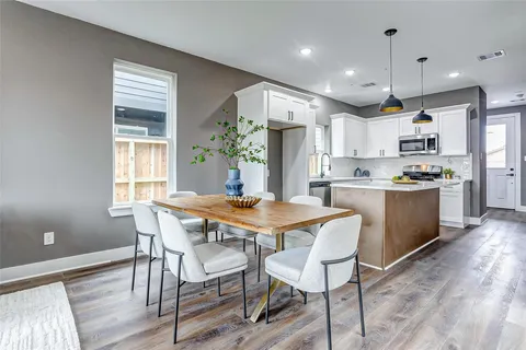 a kitchen with kitchen island a dining table and chairs