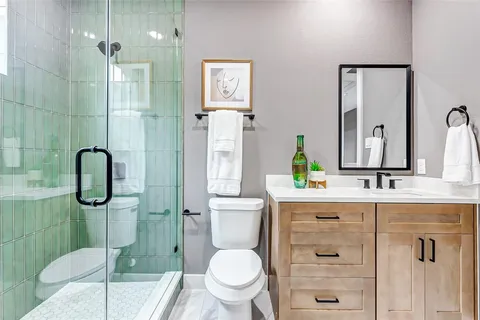 a bathroom with a granite countertop sink toilet and shower