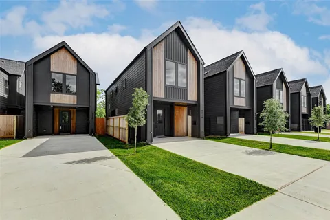 a front view of a house with a yard and potted plants