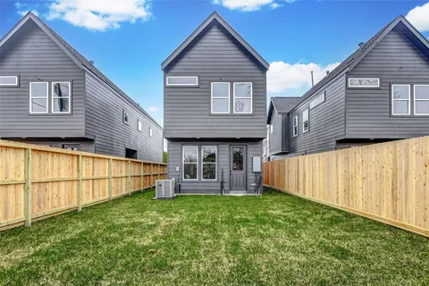 a view of a house with a small yard and wooden fence