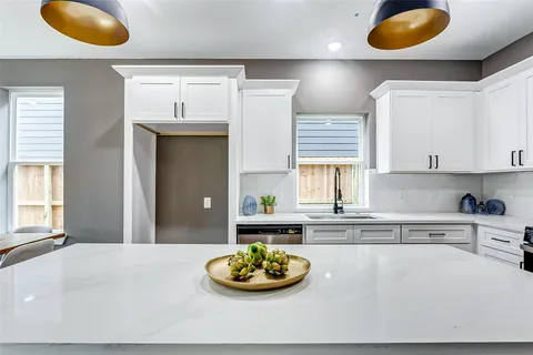 a kitchen with a white cabinets and chairs