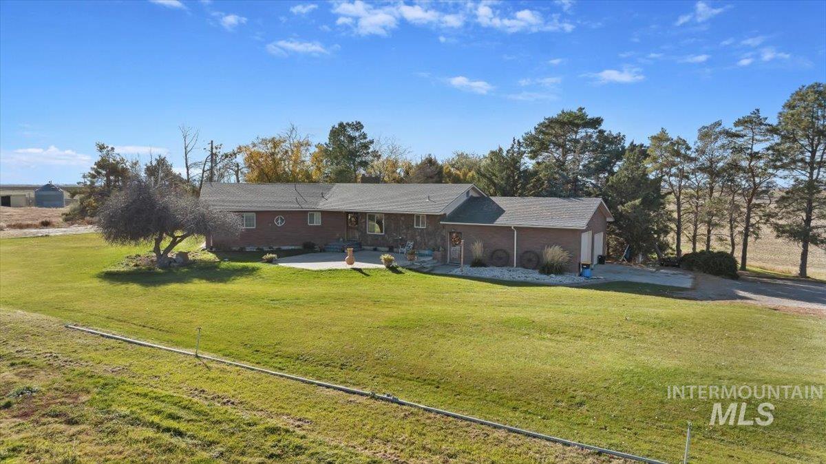 Ranch-style home with a front lawn, an attached garage, and driveway