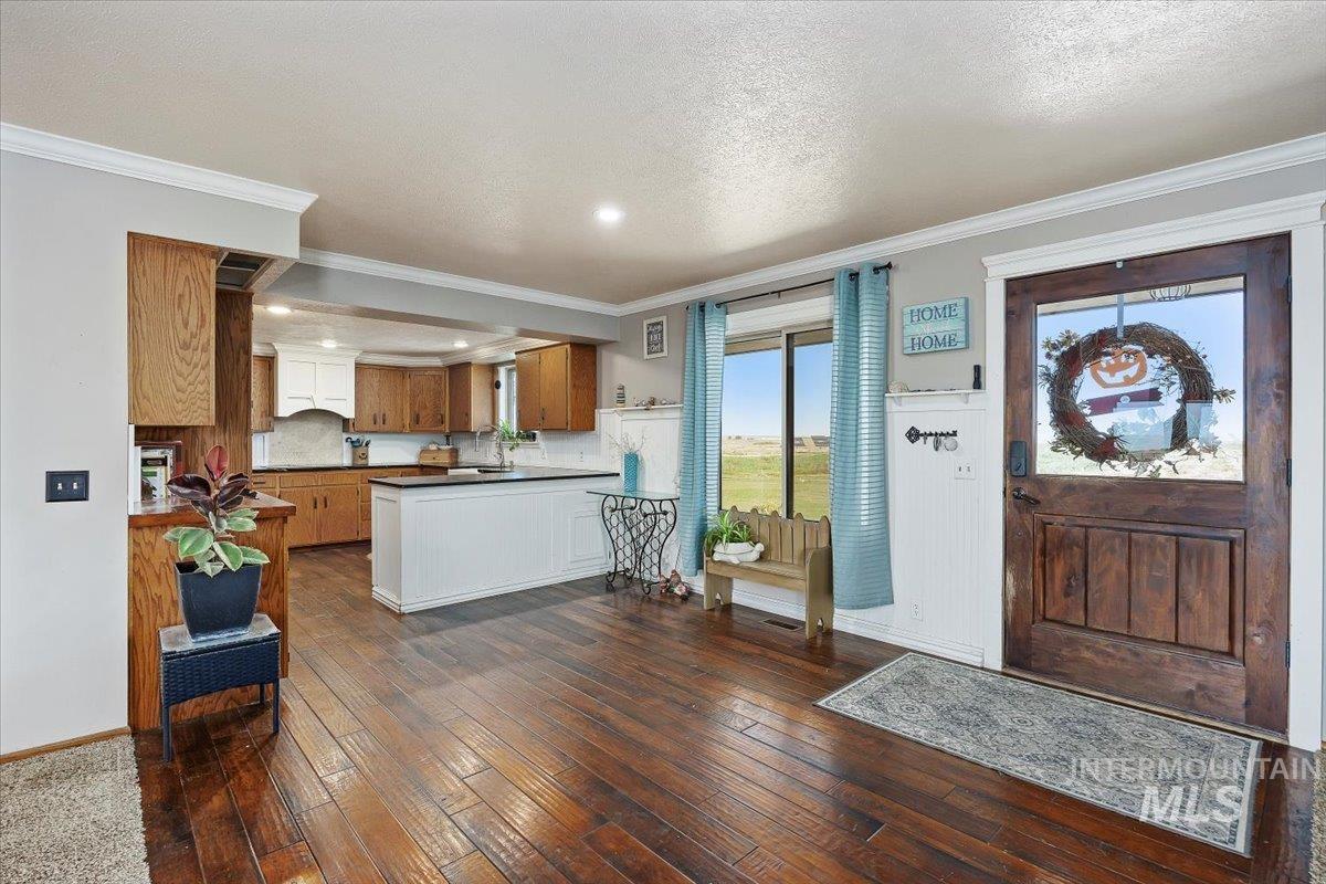 173 Main Line Ranch Road Rupert, ID 83350 - Photo 13 of 47 Foyer with dark wood-type flooring, ornamental molding, and a textured ceiling