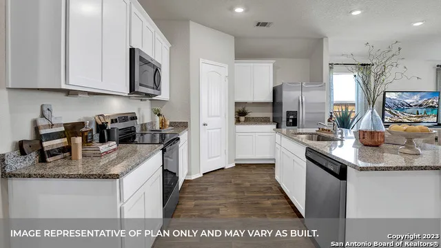 a kitchen with stainless steel appliances granite countertop a sink a stove and cabinets