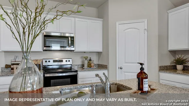 a kitchen with stainless steel appliances granite countertop a stove a microwave a sink and cabinets