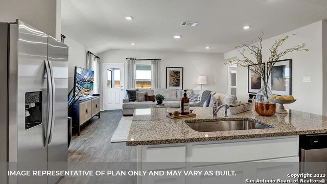 a kitchen with stainless steel appliances granite countertop a sink refrigerator and cabinets