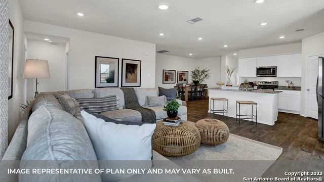 a living room with furniture and kitchen